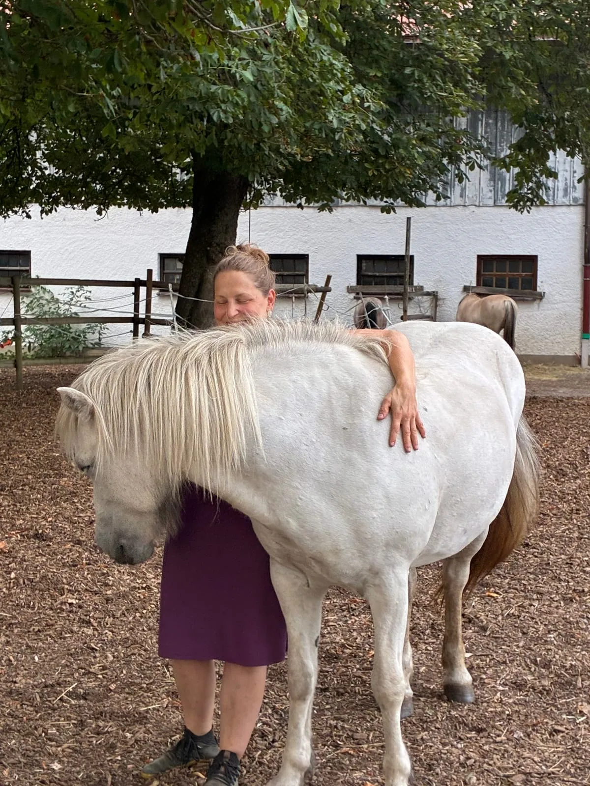 Barbara Maria Placht umarmt ihr Pferd auf dem Hof in Dorfreit